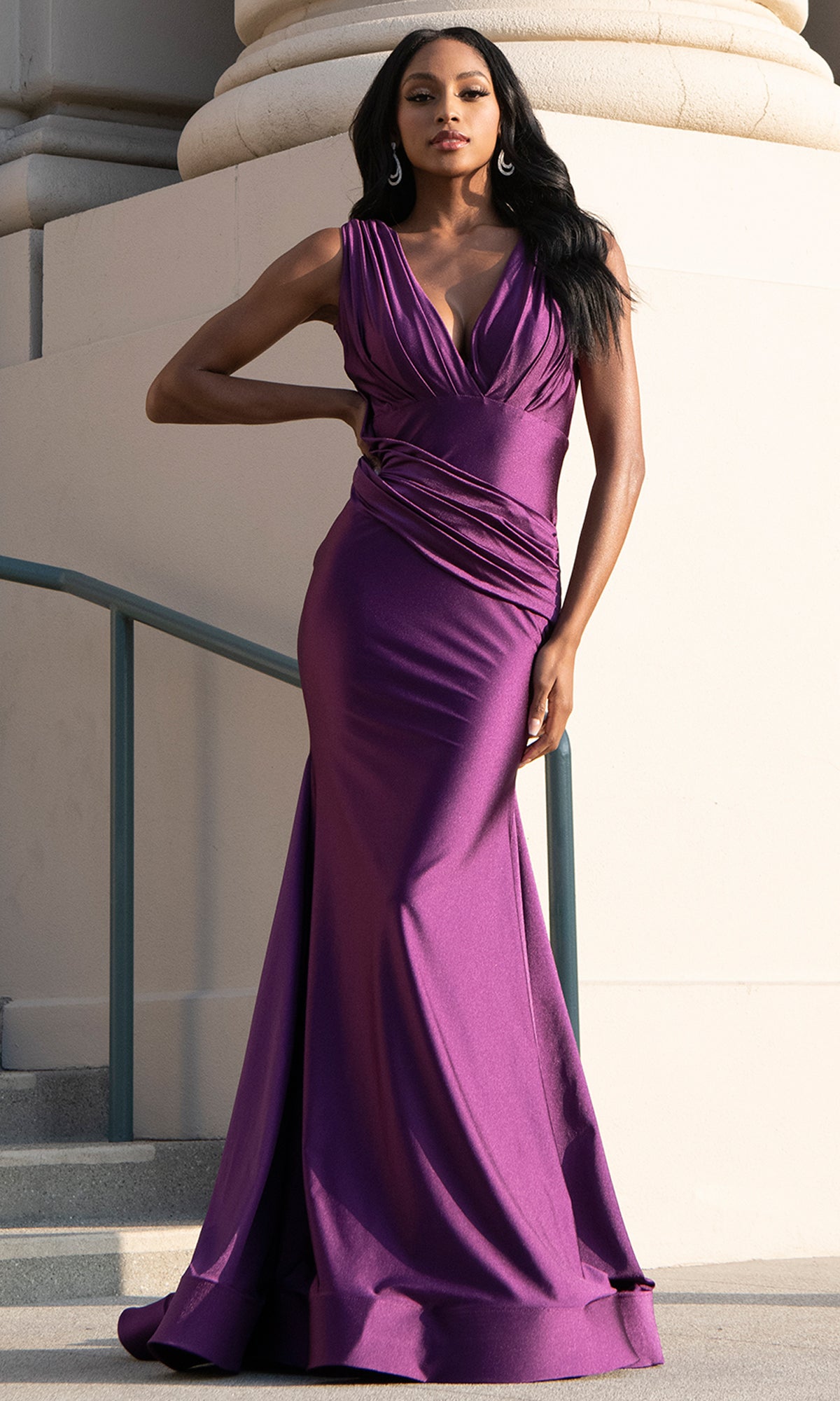 Woman in a purple evening gown standing outdoors.